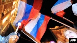 Pro-Kremlin youth activists wave the Russian flag as they rally in Moscow.