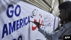 A Pakistani man prepares an anti-U.S. and anti-Facebook banner in Karachi earlier this week.