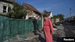 A woman stands next to her house destroyed by a Russian air strike in Zaporizhzhya, Ukraine. October 10, 2024. 