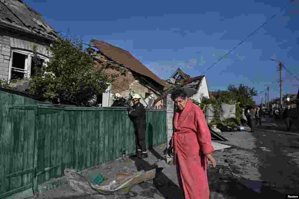 Një grua qëndron jashtë shtëpisë së saj, e cila u shkatërrua nga një sulm ajror rus në Zaporizhja, Ukrainë.