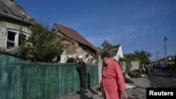 Žena stoji u blizini uništene kuće u ruskom zračnom napadu, Zaporižje, 10. oktobra 2024.