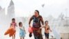 Three kids reluctantly head home after cooling off in a fountain.