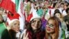 Iranian women cheer as they wave their country's flag after authorities in a rare move allowed a select female group into Tehran's Azadi Stadium to watch a friendly soccer match between Iran and Bolivia in 2018. 