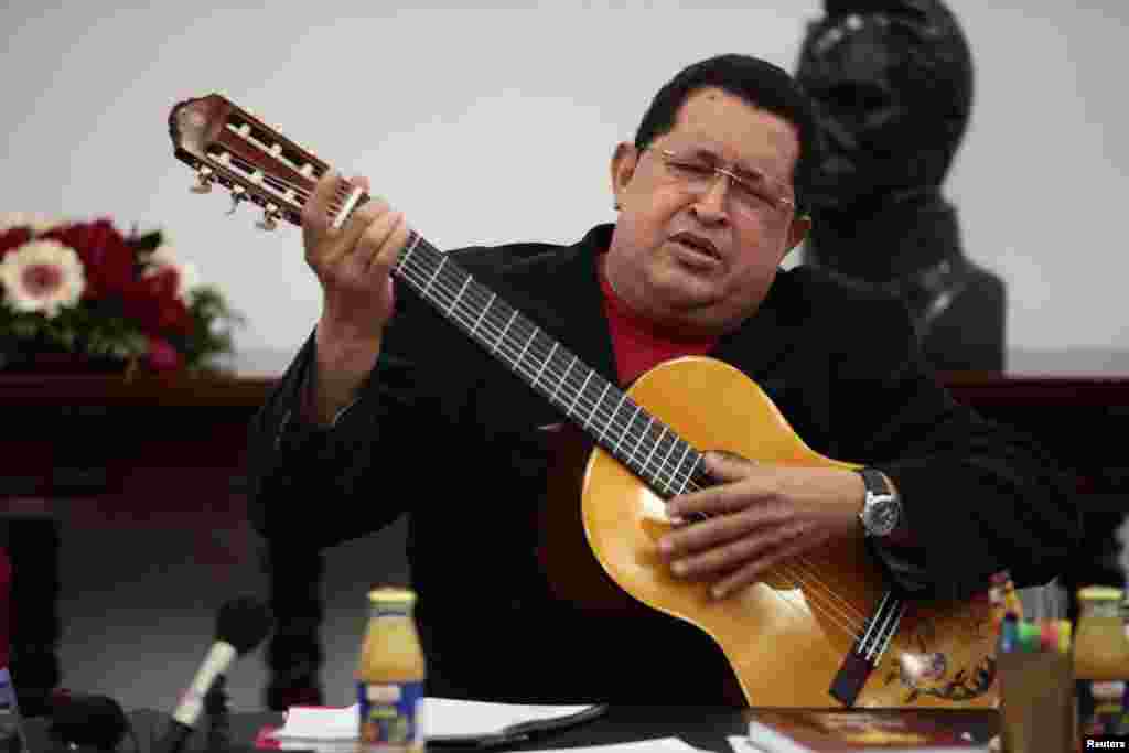 Venezuelan President Hugo Chavez plays a guitar, which was a gift from Mexican singer Vicente Fernandez, during a cabinet meeting at Miraflores Palace in Caracas September 20, 2012.