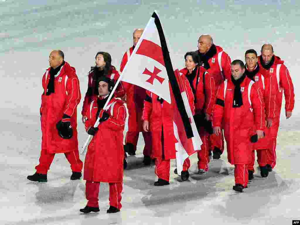 Грузинские спортсмены несут флаг с траурной лентой на открытии зимних Олимпийских игр в Ванкувере 12 февраля. Игры открылись вскоре после трагической гибели саночника Нодара Кумариташвили во время тренировки на олимпийской трассе