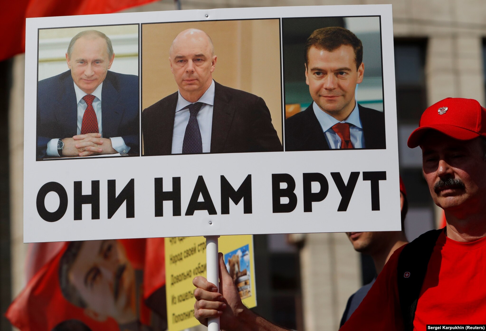 At a September 2, 2018, protest against a proposed increase to the retirement age, an activist's sign shows Putin, Medvedev, and Finance Minister Anton Siluanov with the slogan "They lie to us." 