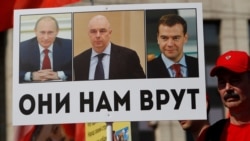 Участник акции протеста против повышения пенсионного возраста (фото 2018 года). На плакате изображены Владимир Путин, Антон Силуанов и Дмитрий Медведев (тогдашний премьер-министр РФ) 