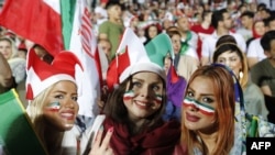 Iranian women cheer as they wave their country's flag after authorities in a rare move allowed a select female group into Tehran's Azadi Stadium to watch a friendly soccer match between Iran and Bolivia in 2018. 