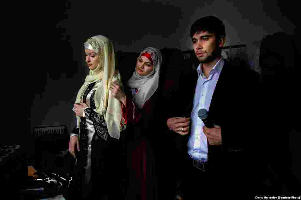 Chechen artists prepare backstage for their performance. All women in Chechnya must wear head scarves in public schools and state buildings. Celebrities were among the first to conform, making the head scarf a fashion statement.