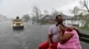 Dvoje građana u američkoj državi Luisiana ispred potopljenih kuća, na kiši i vjetru, nakon što je protutnjao uragan Ida čekaju pomoć, 30. avgusta 2021. 