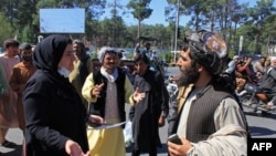 An Afghan woman protester speaks with a member of the Taliban during a protest in Herat on September 2.