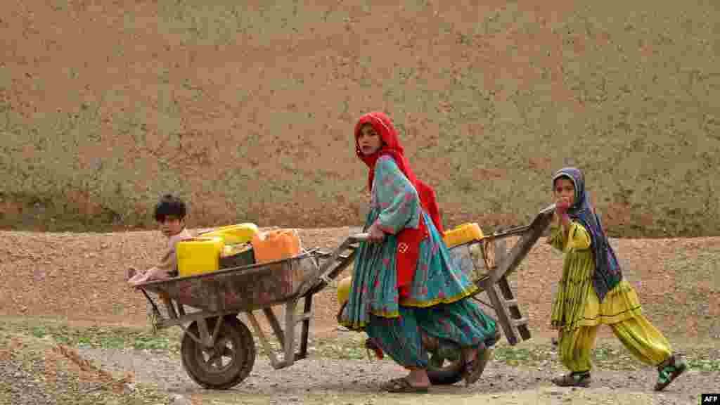 Devojčice iz avganistanskog nomadskog plemena Koči guraju kolica s vodom u okrugu Daman u provinciji Kandahar.