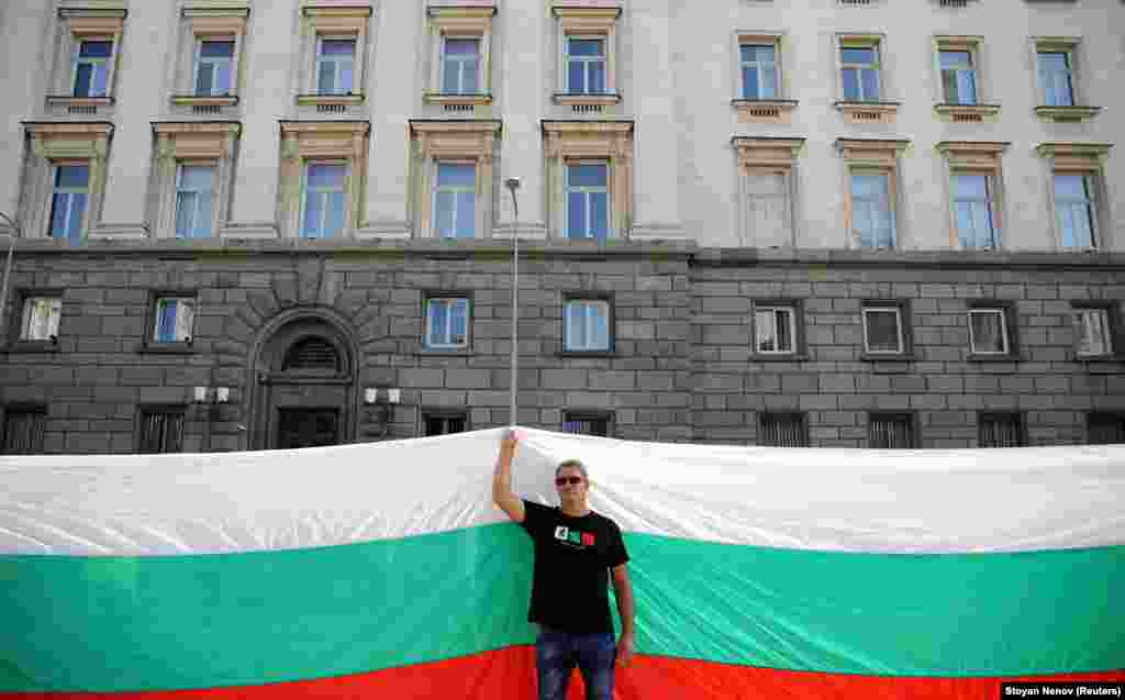 A protester holds a large Bulgarian flag as he attends an anti-government demonstration in Sofia on September 10. (Reuters/Stoyan Nenov)