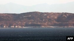 Coasta nord-coreeană cu buncăre de artilerie, văzută de pe insula sud-coreeană Yeonpyeong, în apropiere de „linia de limită nordică” a frontierei maritime cu Coreea de Nord, 7 ianuarie 2024.