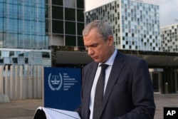 Exiled Belarus opposition activist Pavel Latushka reads from a file after he presented evidence to the International Criminal Court alleging the personal involvement of Belarusian strongman Alyaksandr Lukashenka in the illegal transfer of children to Belarus from Russian-occupied towns in Ukraine, at The Hague on November 7, 2023.
