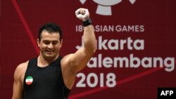 Sohrab Moradi of Iran celebrates after breaking the world record in the men's 94-kilogram class weightlifting event at the 2018 Asian Games in Jakarta on August 25.