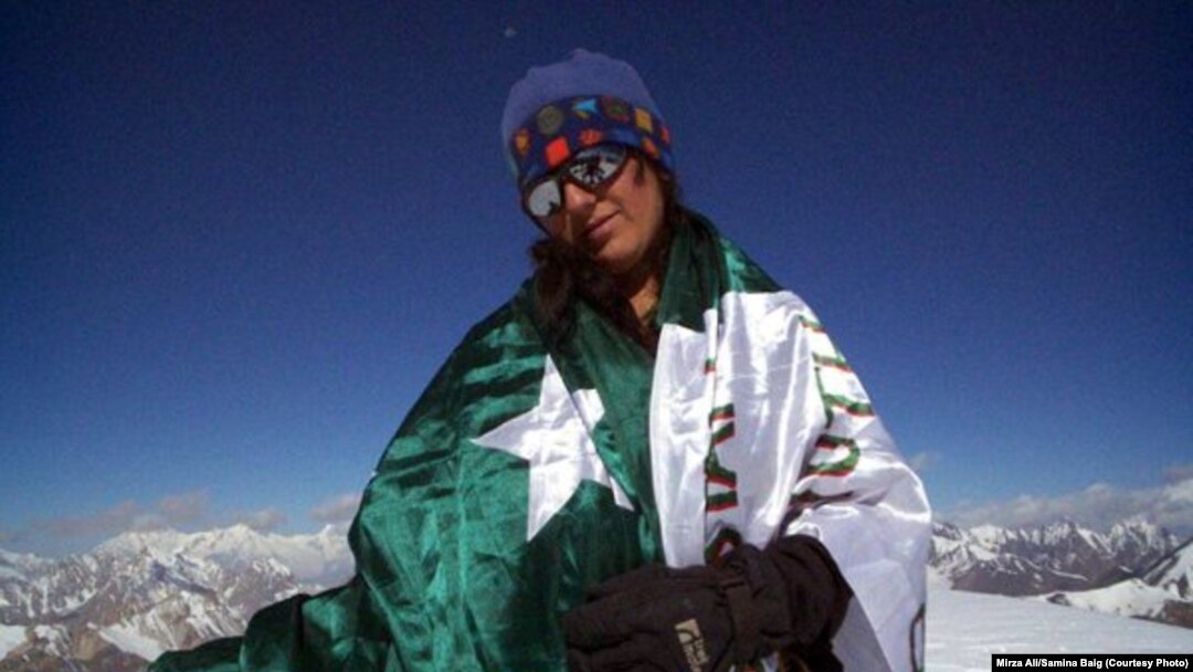 Mountaineer Samina Baig poses with a Pakistani flag during a previous climb.