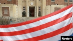 نمایی از پرچم ایالات متحده در مقابل سفارت سابق این کشور در تهران که وارونه نصب شده است
