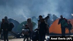 Migrants carry their belongings near the border crossing with Croatia, in Maljevac, Bosnia, in October 2018.