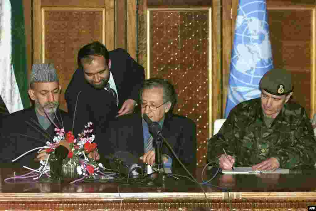 British Major&nbsp;General John McColl (right),&nbsp;UN&nbsp;special representative Lakhdar Brahimi (center),&nbsp;and&nbsp;Karzai during the January 4, 2002,&nbsp;signing of an&nbsp;agreement on the deployment of foreign troops on Afghan soil. 