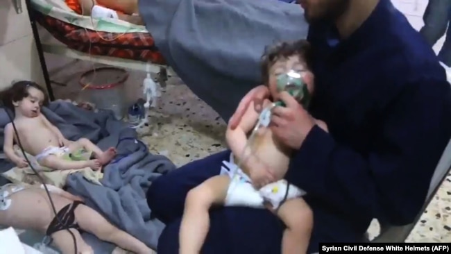 Unidentified volunteers give aid to children at a hospital following an alleged chemical attack on the rebel-held town, April 8, 2018