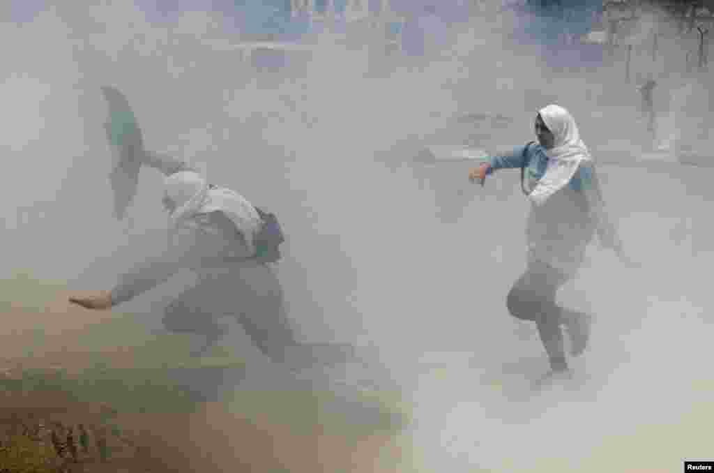 Palestinian schoolgirls run for cover from tear gas fired by Israeli troops during clashes at a protest marking the 69th anniversary of Nakba on May 15 in the West Bank town of Bethlehem. Nakba is the day on which Palestinians mark the displacement that preceded and followed Israel's declaration of independence in 1948. (Reuters/Ammar Awad)