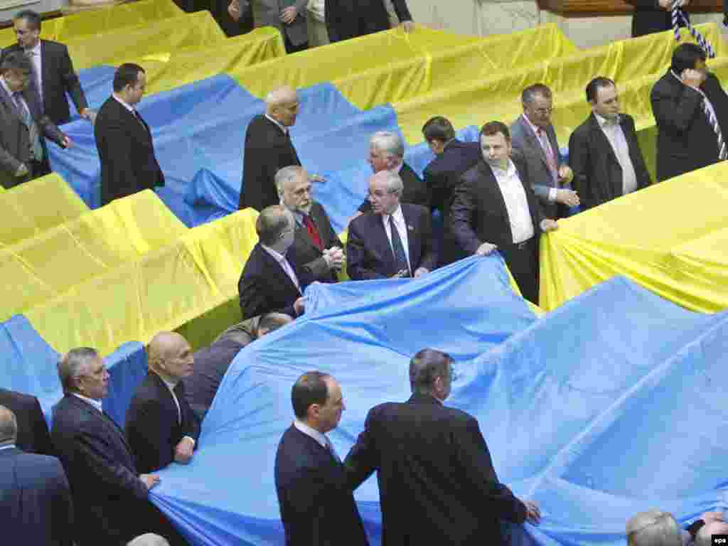 Парламентарии от Блока Юлии Тимошенко и "Нашей Украины - Народной самообороны" накрыли свои места в зале двумя огромными государственными флагами и все это время безуспешно пытались прорваться к трибуне и президиуму, которые защищали представители правящей коалиции.