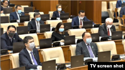 Депутаты в защитных масках на одном из пленарных заседаний мажилиса парламента Казахстана. 