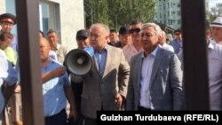 Омурбек Текебаев (слева, с мегафоном) и Дуйшонкул Чотонов на выходе из здания Первомайского райсуда Бишкека. 29 августа 2019 года.