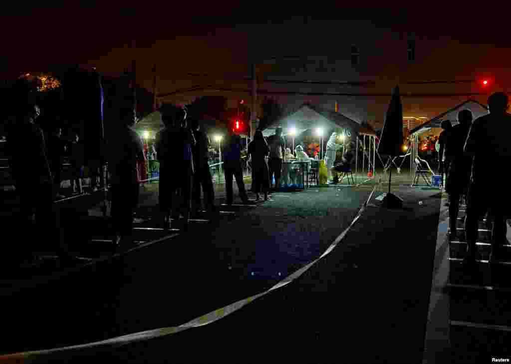 Люди выстраиваются в очередь ночью, чтобы пройти тестирование на нуклеиновые кислоты
