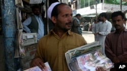 Пакистандык сатуучу бин Ладендин өлүмүн баяндаган жергиликтүү журналдарды сатууда, 2011-жылдын 13-майы.