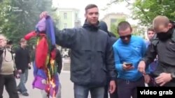 Кадр із відео, на якому видно, як нападники підпалюють прапор ЛГБТ, Харків, 17 травня 2017 року