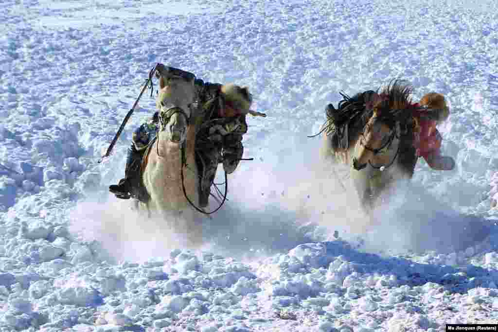 Herdsmen tame horses on a snow-covered pasture in Xilingol in the Inner Mongolia Autonomous Region of China. (Reuters/Ma Jianquan)