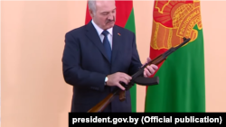 Аляксандар Лукашэнка з падараваным яму колішнім міністрам абароны Беларусі Андрэем Раўковым аўтаматам Калашнікава. Люты 2015