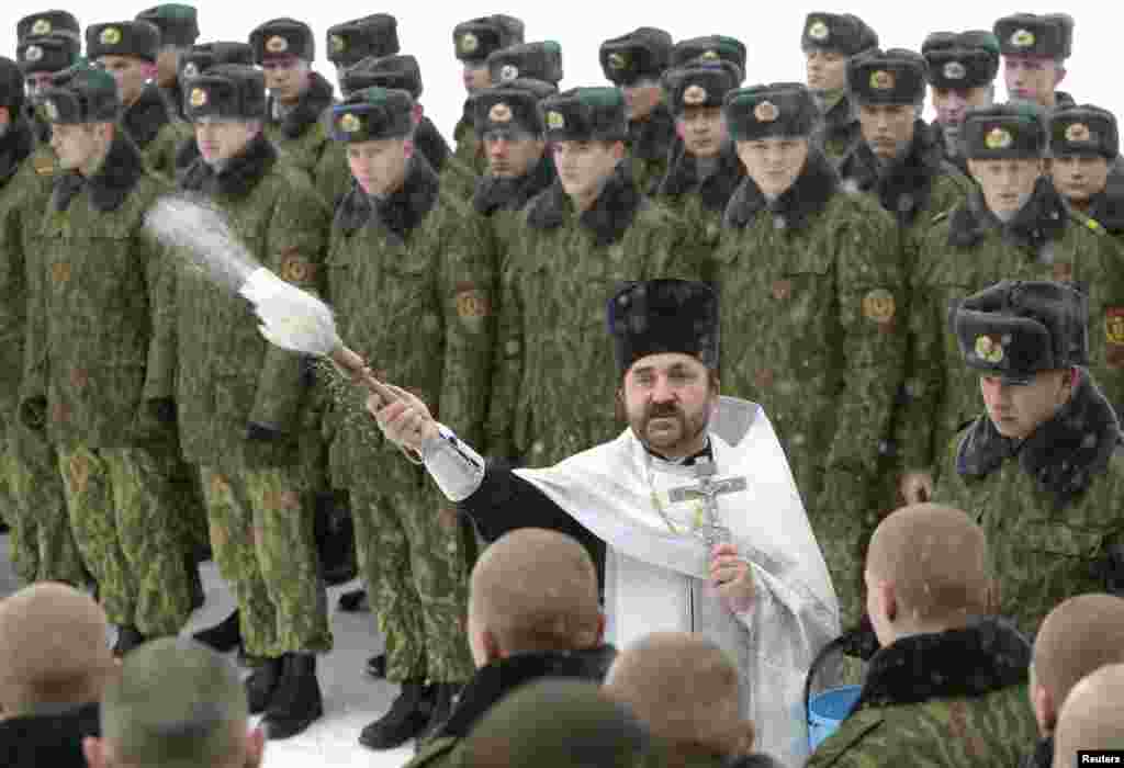 An Orthodox priest blesses servicemen of the Interior Ministry&#39;s special unit during a service at a military base in the Belarusian capital, Minsk. (Reuters/Vasily Fedosenko)