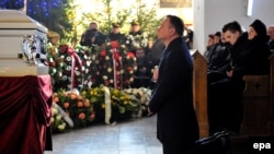 Polish President Andrzej Duda (center) prays at the coffin of Lukasz Urban during a funeral Mass in Banie in northwestern Poland on December 30.