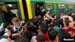 Мигранты штурмуют поезд на вокзале Будапешта, 3 сентября 2015 года. 