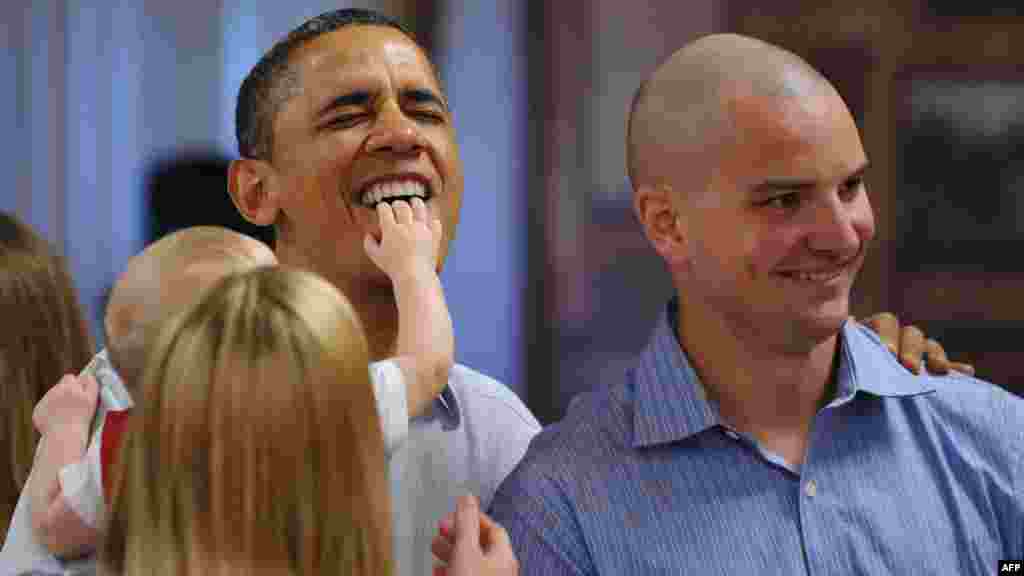 Eight-month-old Cooper Wall Wagner reaches out to touch U.S. President Barack Obama as he poses for a photo with Cooper&#39;s parents, Captain Greg Wagner and Meredith Wagner, while greeting military personnel in Hawaii on December 25. (AFP/ Mandel Ngan)