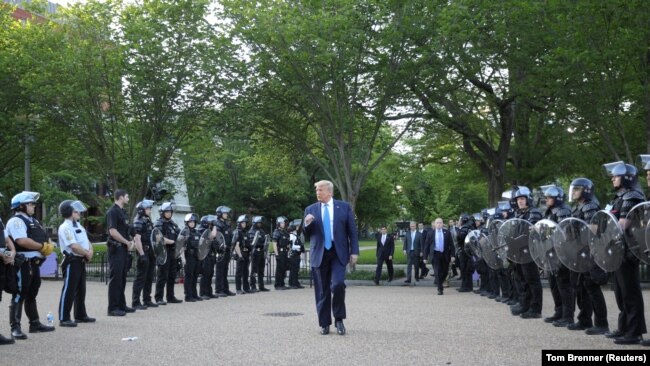 Američki predsednik Donald Trump šeta između policijaca u parku Lafaiette preko puta Bele kuće. 2. jun 2020.