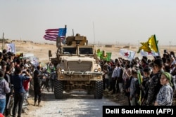 Сирийские курды провожают уходящий из их района конвой армии США. 6 октября 2019 года