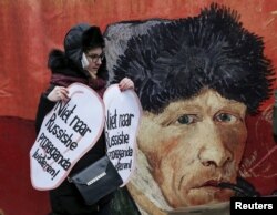 Activist îmbrăcat ca pictorul Vincent van Gogh în fața ambasadei olandeze din Kiev. "Nu ascultați propaganda rusă", spune textul.