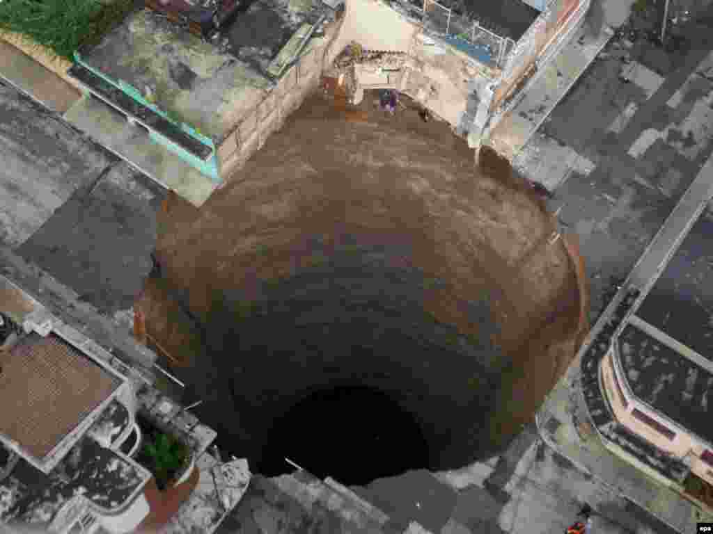 A giant sinkhole caused by the rains of Tropical Storm Agatha is seen in Guatemala City on June 1. Agatha caused mudslides and road collapses that left some 175 people dead. Photo by Luis Echeverria for epa 