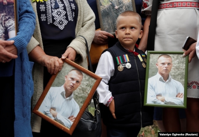 Relatives hold portraits of a Ukrainian serviceman, who was killed in the conflict in eastern Ukraine, during a rally in August 2020 to commemorate the 6th anniversary of the Battle of Ilovaysk.