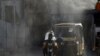 Workers spray disinfectant along a street during a government-imposed nationwide lockdown as a preventive measure against the spread of the COVID-19 coronavirus in Karachi on May 4.