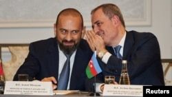 Azerbaijani Foreign Minister Jeyhun Bayramov whispers in the ear of his Armenian counterpart, Ararat Mirzoyan, during a meeting about the Trump Route for International Peace and Prosperity (TRIPP) in New York on September 23. 