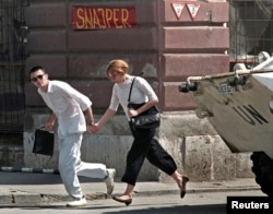  Млада двойка тича през така наречен „ Снайперистка алея “ в Сараево през 1995 година 