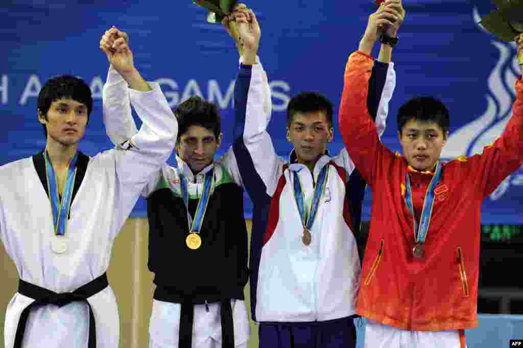 محمد باقری معتمد (از چپ دوم )؛ برنده مدال طلای رشته تکواندو در کنار رقیبانش - گوانگژو، چین