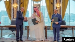 Turkish President Recep Tayyip Erdogan shakes hands with Saudi Crown Prince Muhammad bin Salman, next to Pakistan's Prime Minister Shehbaz Sharif during pact signing ceremony on August 7.