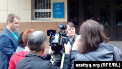 Журналист Александр Баранов (в центре), привлекаемый к уголовной ответственности по обвинению в клевете, дает интервью у здания суда. Павлодар, 11 мая 2016 года.