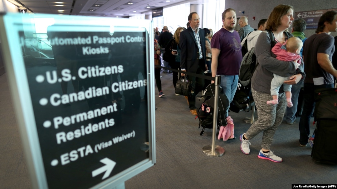 Pasagerii așteaptă la coada pentru ghișeele de control automatizat al pașapoartelor pe Aeroportul Internațional Miami, 4 martie 2015.